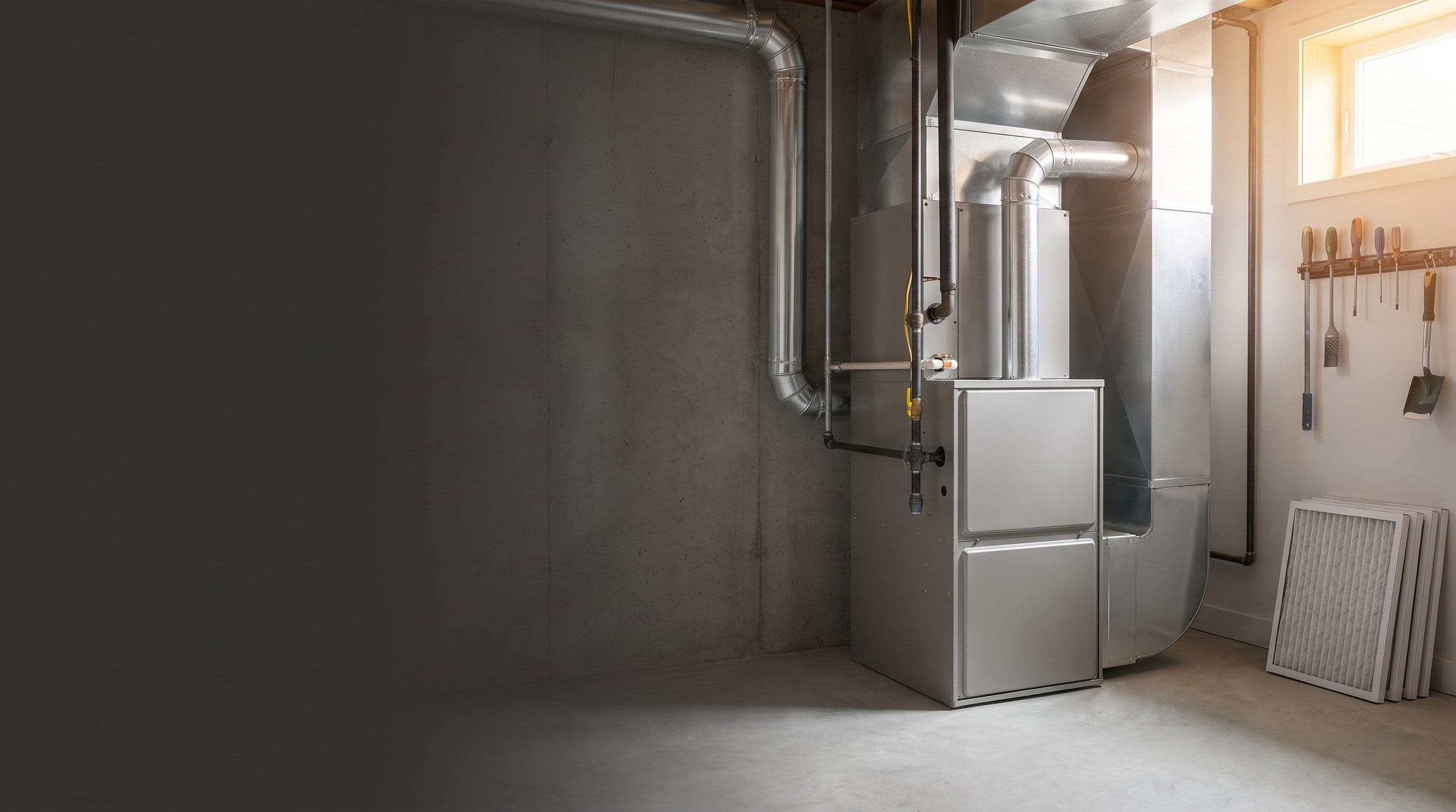A furnace and ductwork in a basement, of the kind replaced during a conversion to electric heating